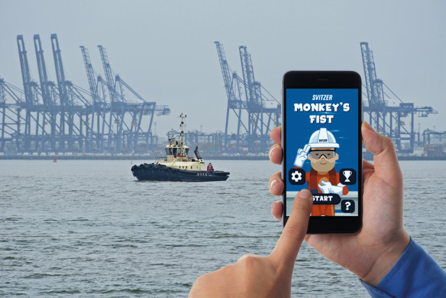 A hand holding a smartphone displaying Svitzer's 