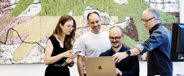 A diverse team of professionals collaborating in a modern office environment, emphasizing the importance of a unified employer brand in fostering a positive work culture across borders.