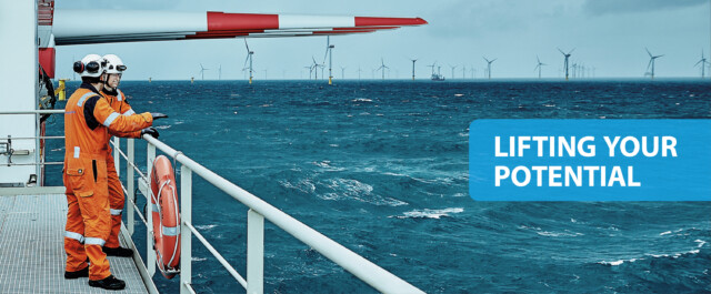 Offshore wind turbine transport vessel with operators and wind turbines in the horizon. Photo and tagline by CBC A/S